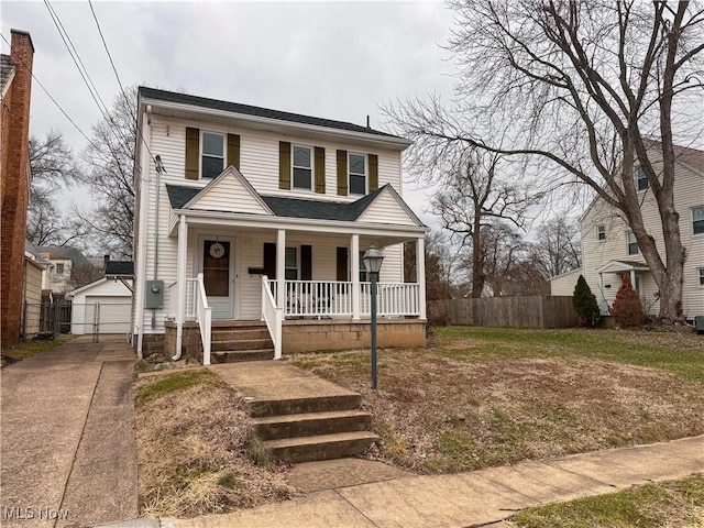 view of front of house featuring a garage, an outbuilding, and covered porch