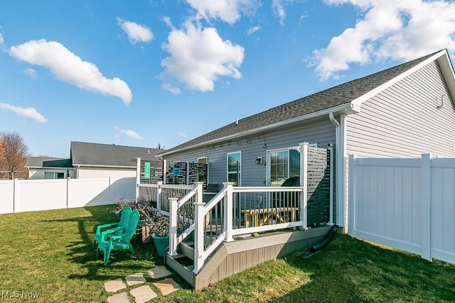 rear view of house with a yard, a fenced backyard, and a wooden deck