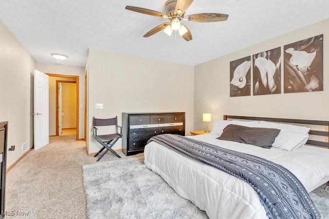 bedroom featuring ceiling fan, baseboards, a textured ceiling, and light colored carpet