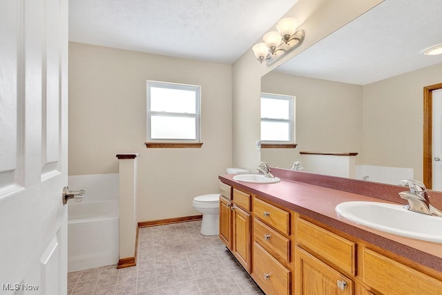 full bath with a garden tub, a sink, baseboards, and double vanity