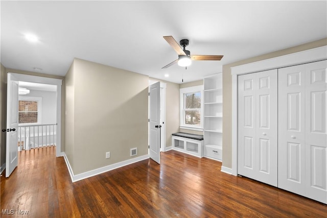 unfurnished bedroom featuring dark wood-type flooring, a closet, and ceiling fan