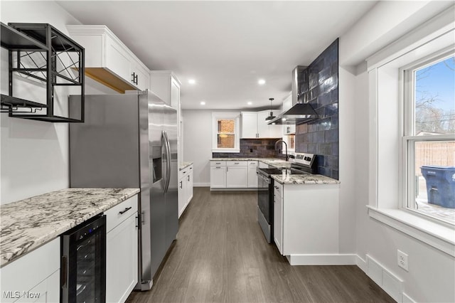 kitchen with white cabinetry, light stone counters, stainless steel appliances, and beverage cooler