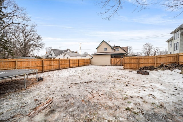 snowy yard featuring a trampoline