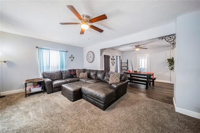 living room featuring ceiling fan and dark colored carpet