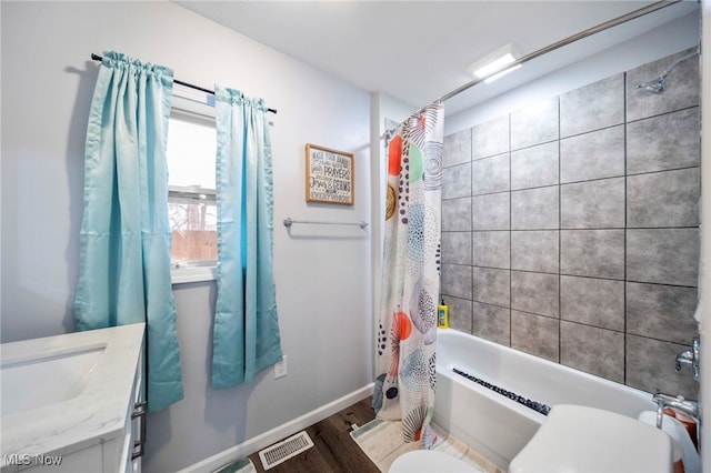 full bathroom featuring hardwood / wood-style flooring, vanity, shower / tub combo, and toilet