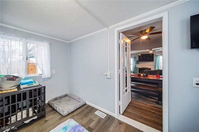 interior space with crown molding, hardwood / wood-style floors, and a textured ceiling