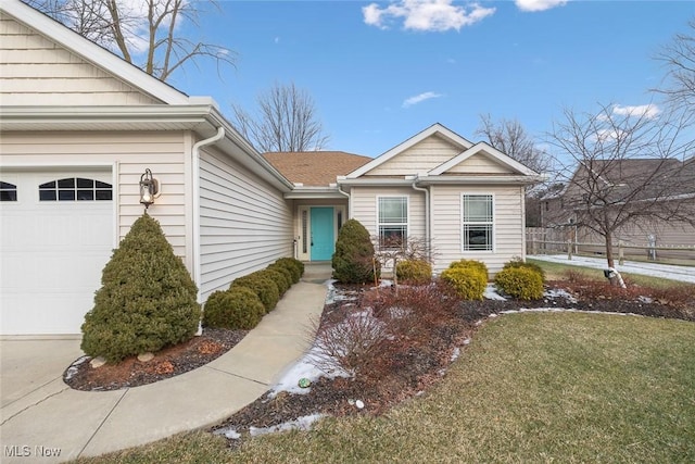 entrance to property with a garage and a lawn