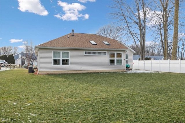 back of house featuring a lawn and central air condition unit