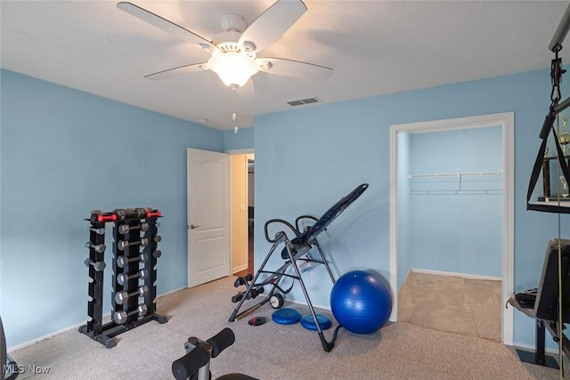 exercise area featuring light carpet and ceiling fan