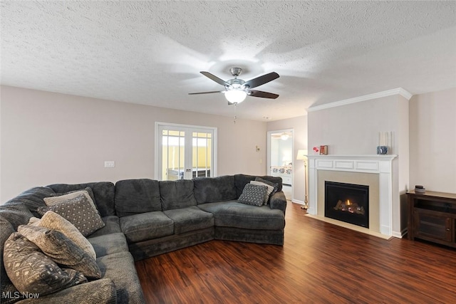 living room with a textured ceiling, dark wood-type flooring, french doors, and ceiling fan