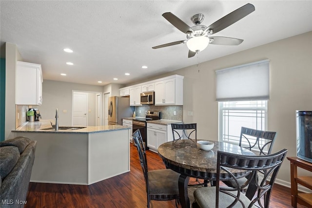 dining room with sink, dark hardwood / wood-style floors, and ceiling fan