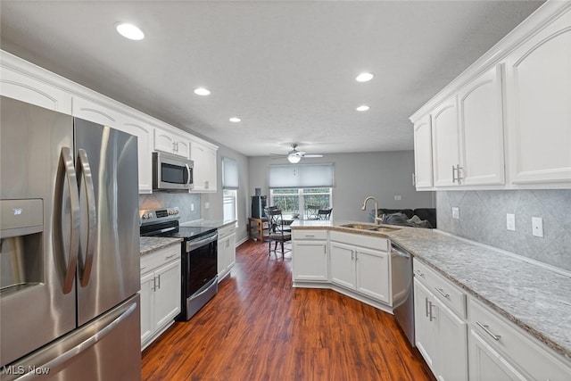 kitchen featuring appliances with stainless steel finishes, sink, white cabinets, and kitchen peninsula