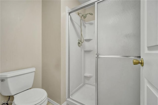 bathroom with toilet and an enclosed shower