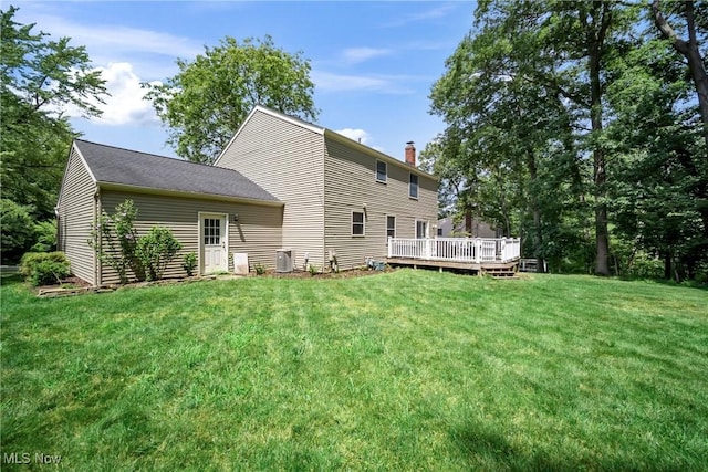 rear view of property featuring a wooden deck, a yard, and central air condition unit