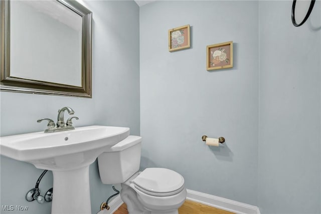 bathroom with wood-type flooring and toilet