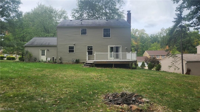 back of house with a yard, a deck, and a fire pit