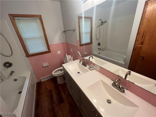 full bathroom with tile walls, vanity, wood-type flooring, bathtub / shower combination, and toilet