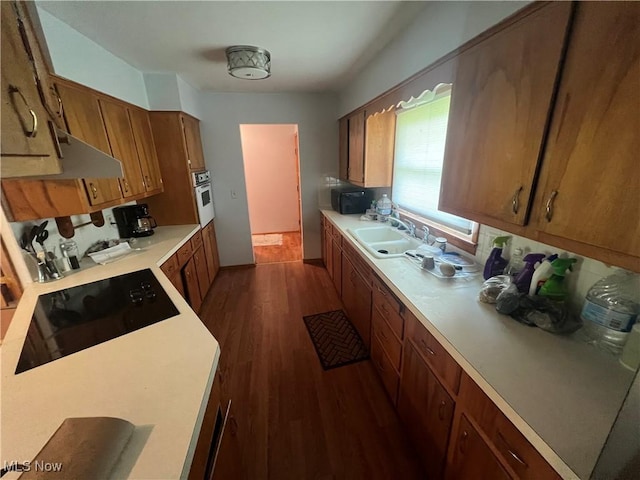 kitchen with sink, dark hardwood / wood-style floors, and black appliances