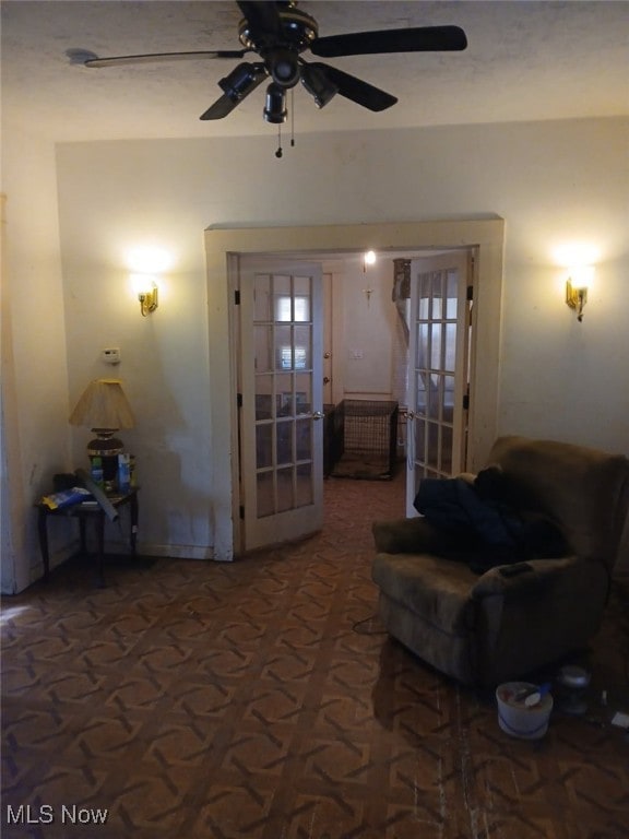 living room featuring ceiling fan and french doors