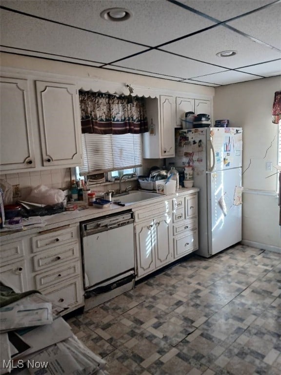 kitchen featuring a drop ceiling, sink, white appliances, and white cabinets