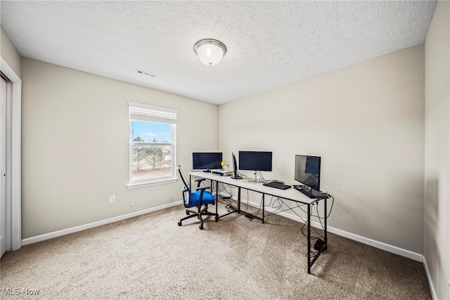 carpeted office space featuring a textured ceiling