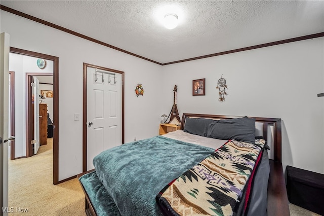 carpeted bedroom with ornamental molding and a textured ceiling