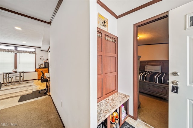 hall with crown molding and light colored carpet