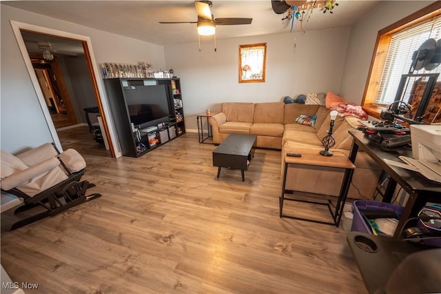 living room with light hardwood / wood-style flooring and ceiling fan