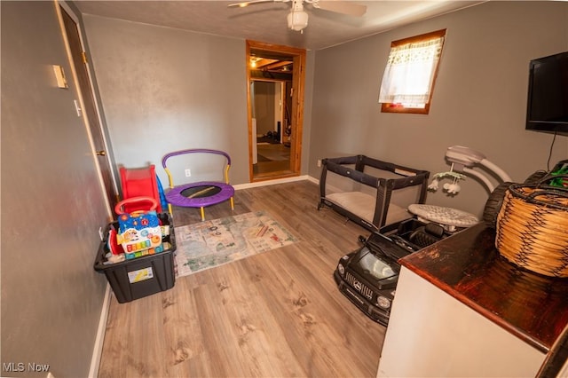 playroom with wood-type flooring and ceiling fan