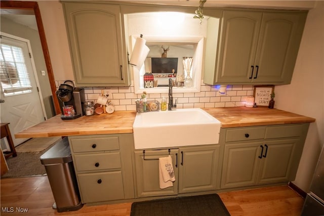 kitchen with butcher block counters, sink, and backsplash