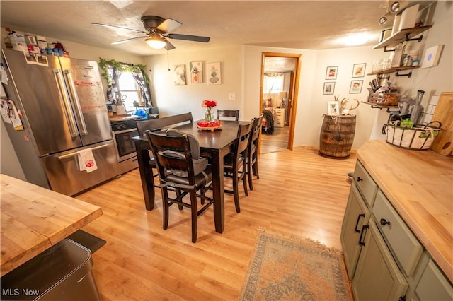 dining area with ceiling fan and light hardwood / wood-style flooring