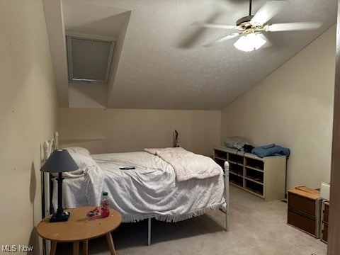 bedroom with lofted ceiling, ceiling fan, a textured ceiling, and light carpet