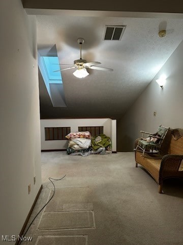 additional living space with carpet floors, vaulted ceiling with skylight, visible vents, and a ceiling fan