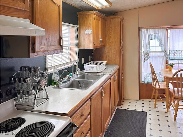 kitchen with electric stove, sink, and a textured ceiling