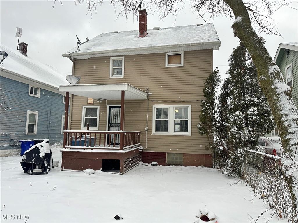 view of snow covered back of property