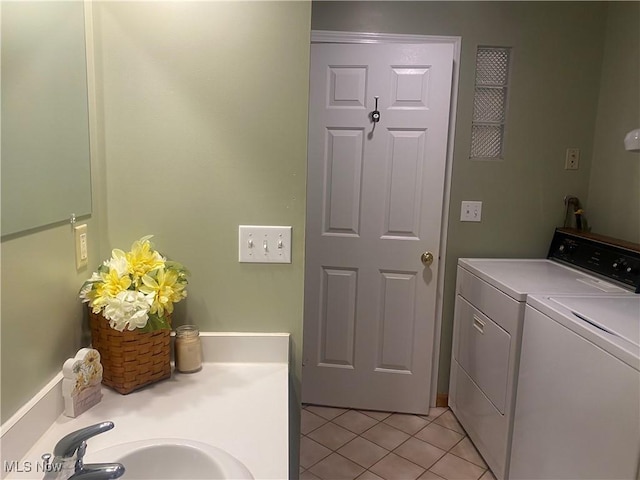 clothes washing area featuring washing machine and dryer, sink, and light tile patterned floors