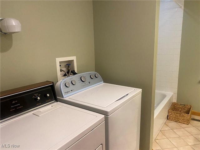 washroom with washing machine and dryer and light tile patterned floors