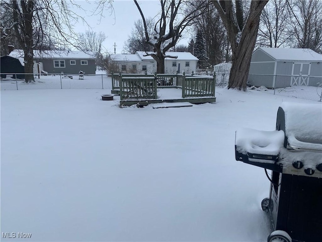 yard covered in snow with a deck