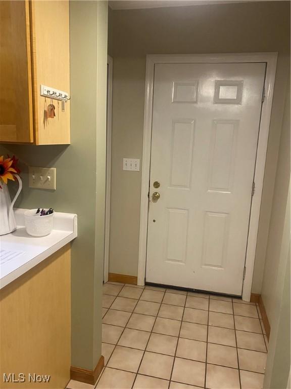 doorway with light tile patterned floors