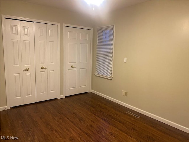 unfurnished bedroom with dark wood-type flooring