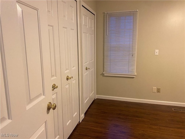 unfurnished bedroom with dark hardwood / wood-style flooring