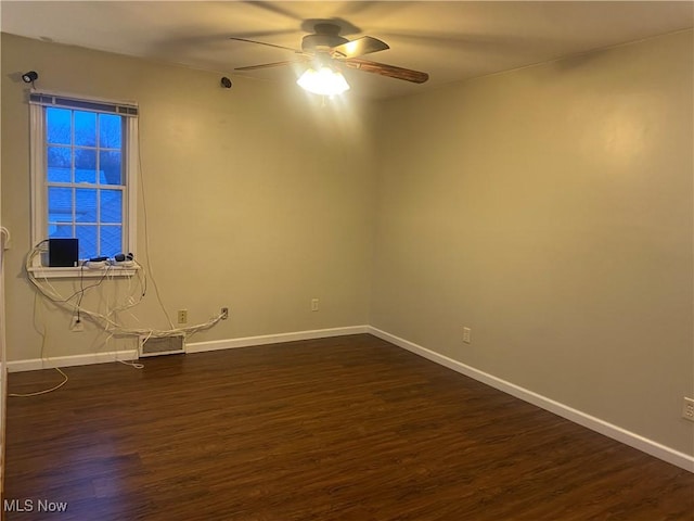 unfurnished room featuring dark wood-type flooring and ceiling fan