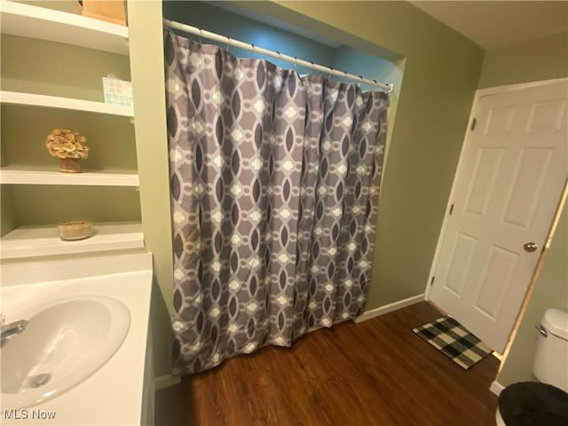 bathroom featuring hardwood / wood-style flooring, toilet, and sink