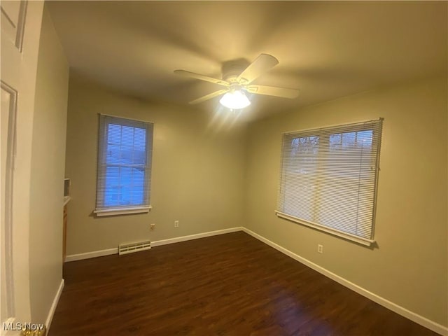 unfurnished room with ceiling fan and dark hardwood / wood-style flooring