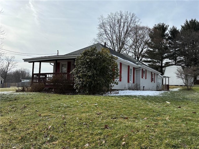 view of side of property with a porch and a lawn