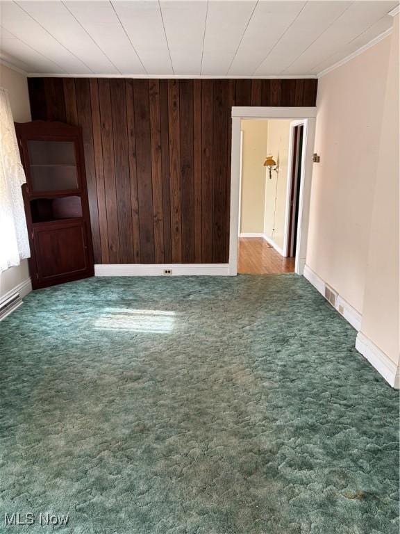 empty room with ornamental molding and dark carpet