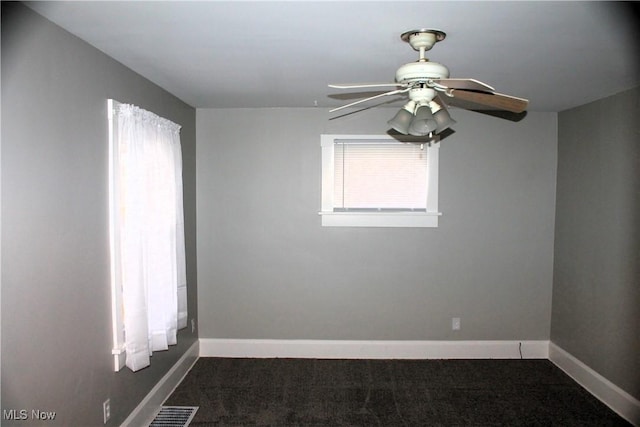 empty room with carpet flooring, a ceiling fan, and baseboards