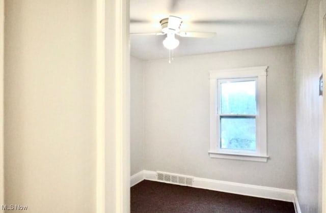 carpeted empty room featuring ceiling fan