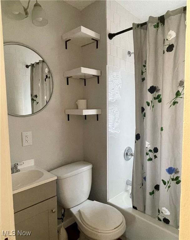 full bathroom with vanity, toilet, and shower / bath combo with shower curtain