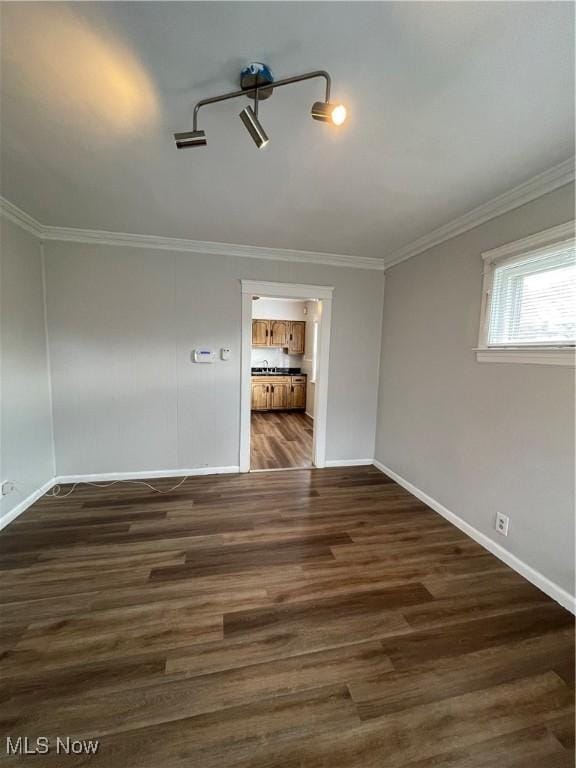 spare room featuring ornamental molding and dark hardwood / wood-style floors